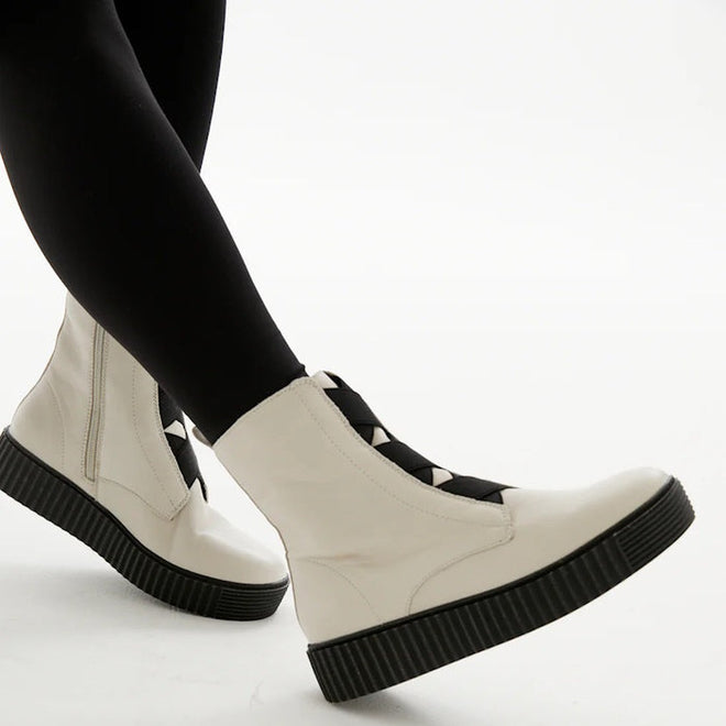 Alfie & Evie Date boot in stone leather with elastic cross-over front detail, side zip and chunky black Elevate Platform Sole – women’s ankle boot. On models feet sowing outside and inside of leg views