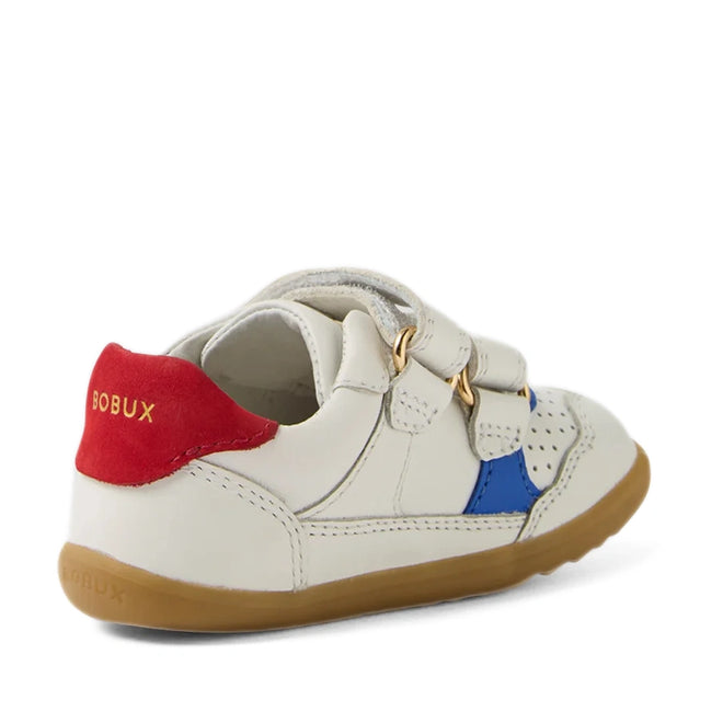 A small white leather sneaker with easy velcro straps, featuring blue and red (salsa) accents and a tan rubber sole—ideal as first walker shoes. The gold-printed BOBUX branding on the red heel tab adds a stylish touch, making the Bobux SU Step Up Hunter Leather Toddlers Sneaker White Salsa both practical and fashionable for little ones on the go.