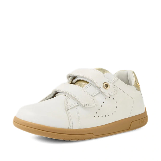 The Bobux Kid+ Plus KP Maverick Leather Sneaker White Gold showcases a pristine white leather finish with stylish gold detailing, two adjustable velcro straps for a secure fit, subtle side perforations for breathability, and a light brown rubber sole. These comfortable kids’ sneakers are thoughtfully displayed on a plain white background.