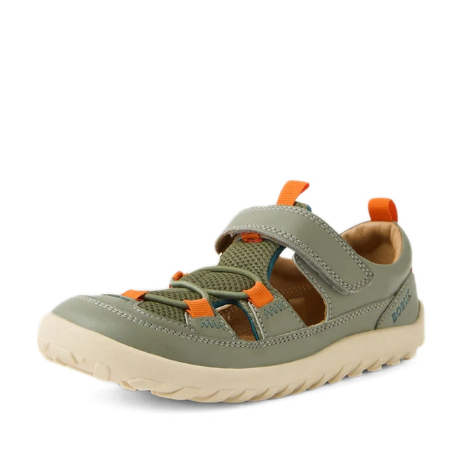 The Bobux Kid+ KP Rocky Leather Closed Toe Sandal in Vetiver Green is a kids’ sandal featuring a green and beige leather design with orange accents, breathable mesh panels, a Velcro strap for easy fastening, and a rugged sole—perfect for outdoor or casual wear.