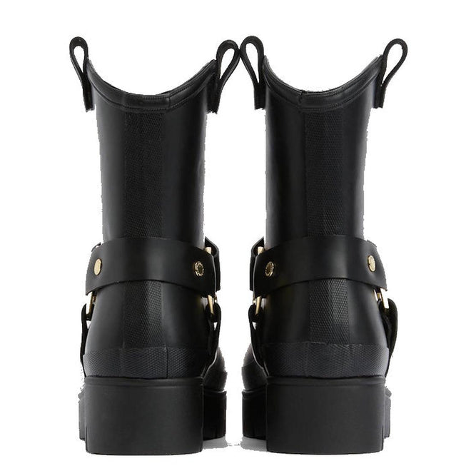 A pair of black Barbour Elley Harness Wellington womens rainboots shown from the back, featuring chunky heels, pull tabs, and gold-tone hardware straps—a modern twist on classic black rubber boots., 5020985983018, 5020985983575, 5020985984107, 5020985984558, 5020985984947, 5020985985340