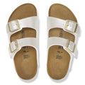 A pair of Birkenstock Kids Arizona Metallic Pearl White Narrow Slides with two adjustable straps, silver buckles, and a cork footbed, displayed from above on a plain white background., 48068, 48069, 48070, 48071, 48072, 48073, 48074, 48075, 48076