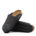 A pair of Birkenstock Amsterdam Felt Wool Clog Anthracite Grey (Regular Width) is shown: one stands upright and the other lies on its side, displaying the textured black sole and cork footbed.