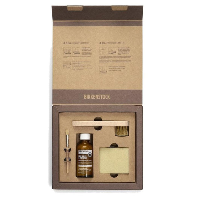Open box containing a Birkenstock Suede Shoe Care Pack Kit with cleaning brush, cleaner bottle, sponge, wooden handle, and metal tool. Printed instructions are on the inside lid.
