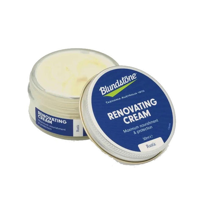 An open jar of Blundstone Renovating Cream Rustic NOT RETURNABLE, a pigmented leather cream in a blue and white container, sits with its lid beside it, offering maximum nourishment and protection for leather shoes.