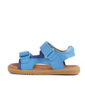 The Bobux IW Iwalk Strand Sandal in Azure Blue is a single toddler sandal with two adjustable straps, a cushioned brown sole, and an open toe. Made from washable material, it's shown in profile against a white background., 9420068556997, 9420068557000, 9420068557017, 9420068557024, 9420068557031