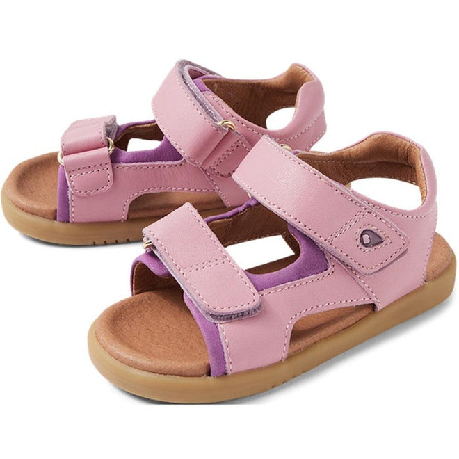 The Bobux IW Iwalk Strand Sandal Lilas Pink Open Toe for toddlers features adjustable Velcro straps, light brown soles, and purple accents on the inner lining.