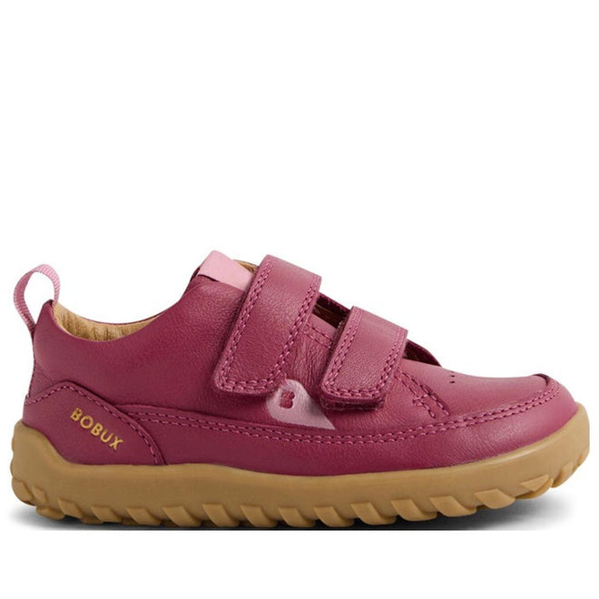 The Bobux IW Iwalk Dawn Toddlers Leather Sneaker Beaujolias is a pink leather sneaker for kids with a barefoot-shaped toe box, tan rubber sole, two velcro straps, and "BOBUX" in yellow on the heel.