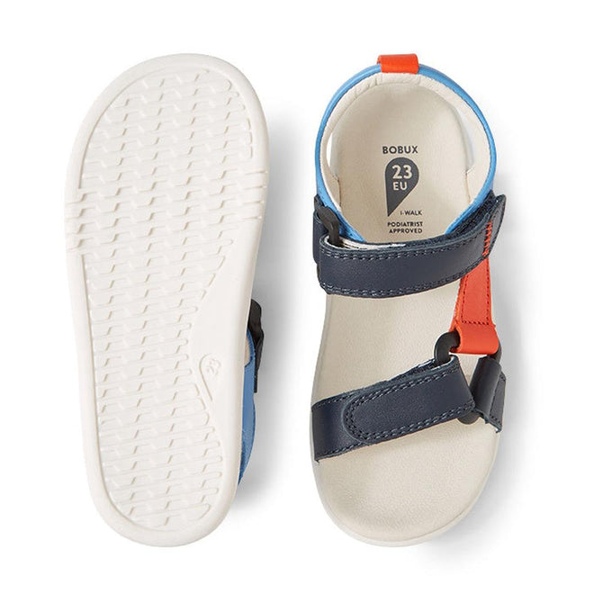 A pair of Bobux IW Iwalk Vine Sandal Navy Open Toe for kids, size 23 EU, with navy and orange double straps, ultra-soft leather, white soles—one sandal shows the tread; the other displays its insole and size label., 9420074820136, 9420074820143, 9420074820150, 9420074820167, 9420074820174