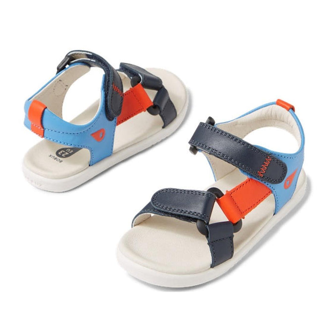 The Bobux IW Iwalk Vine Sandal Navy Open Toe features blue, navy, orange, and white double-strap closures with cushioned white soles. The ultra-soft leather kids’ sandals are displayed at various angles on a white background.