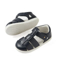 A pair of Bobux IWalk Tidal Closed Toe Quick Dry Sandals in navy (model 634404A) for kids, featuring a unisex design with white soles, crafted from quick-dry leather and equipped with adjustable Velcro straps, displayed on a white background.