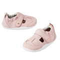 The Bobux XP Explorer Beau First Walker Sandal in Ballet Pink features premium leather, a closed toe, cut-out sides, adjustable Velcro straps, and white flexible soles, displayed against a white background.