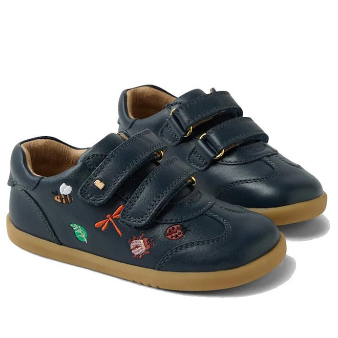 The Bobux Iwalk Buggie Navy Embroidered Toddlers Trainer features navy leather with tan soles, Quickdry finish, bee, leaf, dragonfly, ladybug, and snail embroidery, plus two Velcro straps for easy fastening.