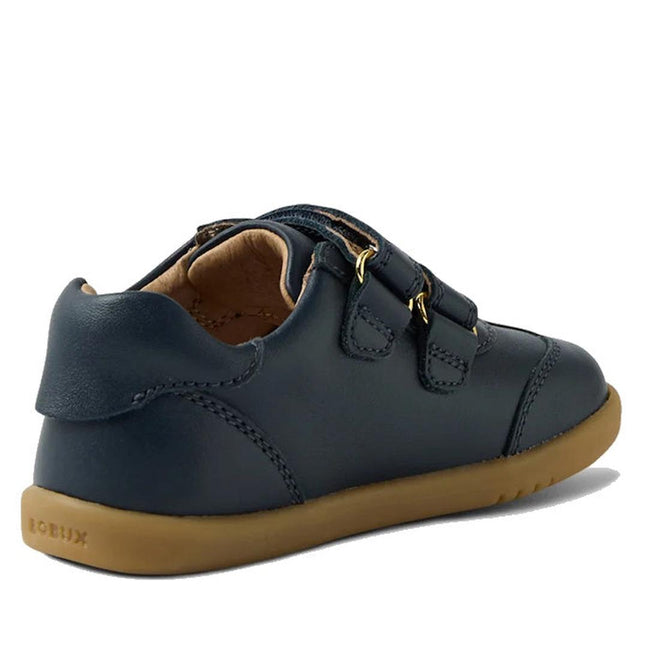 The Bobux Iwalk Buggie Navy Embroidered Toddlers Trainer is a dark blue kids' shoe with two Velcro straps, a light brown rubber sole, Quickdry leather, and "BOBUX" embossed on the heel, shown from a rear side angle on white., 9420074829283, 9420074829290, 9420074829306, 9420074829313, 9420074829320