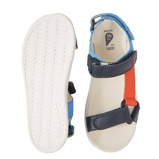 The Bobux Kid+ Plus Vine Leather Navy Open Toe Sandal Junior features water-friendly leather, navy with red and light blue straps, a white sole, an adjustable strap for a secure fit, and an open toe design perfect for kids., 9420074820358, 9420074820365, 9420074820372, 9420074820389, 9420074820396, 9420074820402, 9420074820419