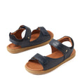 Certainly! Here’s a rewritten version of your sentence using the provided product data: Two pairs of Bobux Kid+ Plus Driftwood Navy Open Toe Sandal 833501AA feature navy blue leather straps and brown cushioned insoles for all-day comfort. These kids’ sandals are designed with adjustable straps for a secure fit and light brown rubber soles, all beautifully displayed against a clean white background.