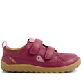 The Bobux Kid+ Dawn Leather Sneaker in Beaujolais Purple is a kids’ shoe with a tan rubber sole, barefoot-shaped toe-box, two velcro straps, yellow BOBUX branding on the side, textured sole, and a small loop at the heel.