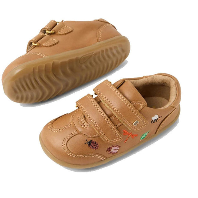 The Bobux Step Up Buggie Embroidered First Walker Sneaker in Caramel features tan leather, rubber soles, Velcro straps, and colorful ladybug, dragonfly, and flower embroidery. Shown on a white background., 9420074828552, 9420074828569, 9420074828576