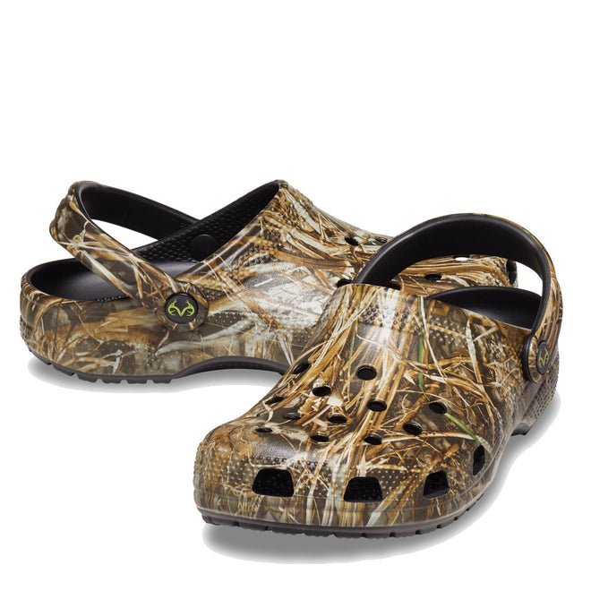 The Crocs Classic Clog Realtree MAX7 Adults Unisex features a camouflage design, ventilation holes, a pivoting heel strap, and lightweight Croslite foam. Shown against a white background.