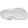 The Crocs Adults Classic Animal Clog Almond Tint Leopard is shown from the bottom, featuring a textured sole with deep grooves, circular patterns, and the Crocs logo embossed in the center for supportive comfort., 51497, 198445344978, 198445344961, 198445344985, 51501, 51502, 51503
