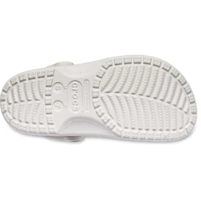 The Crocs Adults Classic Animal Clog Almond Tint Leopard is shown from the bottom, featuring a textured sole with deep grooves, circular patterns, and the Crocs logo embossed in the center for supportive comfort., 51497, 198445344978, 198445344961, 198445344985, 51501, 51502, 51503