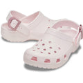 The Crocs Adults Classic Enamel Buckle Clog Bubble Ice Pink features ventilation holes, an adjustable back strap with round dark pink buckles, textured soles, and cushioned Croslite foam for all-day comfort.