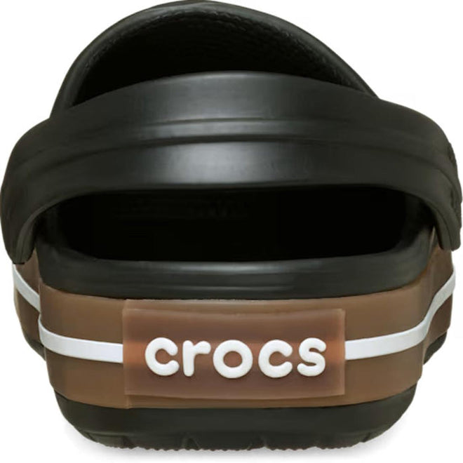 Close-up of the Crocs Adults Crocband Gum Clog Black Unisex, highlighting its Croslite foam comfort, white stripe detail, and "crocs" in white lettering on a brown heel tab., 50028, 198445372889, 198445372896, 198445372902, 198445372919, 198445372926, 198445372834, 198445372841, 198445372858, 198445372865