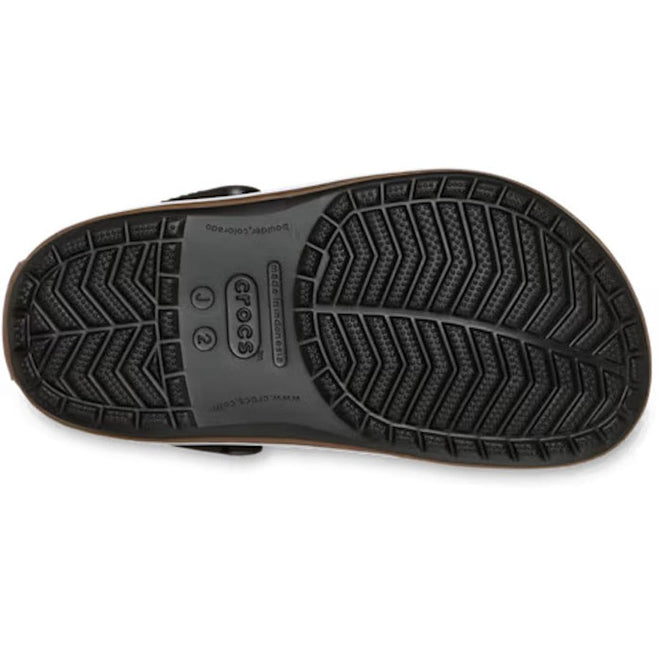 Bottom view of a black Crocs Kids Crocband Gum Clog showing the textured, chevron-patterned tread and the brand logo molded into the sole.