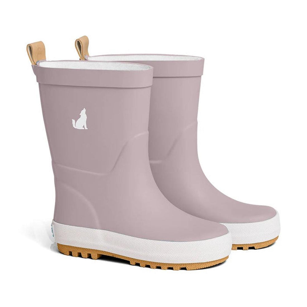 CryWolf Rain Boots Mauve are children’s rain boots in a light purple shade, featuring white soles with brown treads and a small white wolf silhouette on the side. Made from natural rubber, these waterproof boots keep little feet dry and stylish during rainy days.
