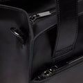 Close-up of the Dr Martens Black Leather Tote Bag Mayhem RB, featuring two zippered compartments, sturdy handles, a side metal D-ring, and an adjustable crossbody strap for versatile carrying options., 190665739572