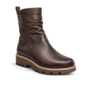 The Django & Juliette Dixeya Chocolate Leather Boot features a side zipper, ruched details, and a chunky tan treaded sole—making it a stylish choice for women seeking leather ankle boots.