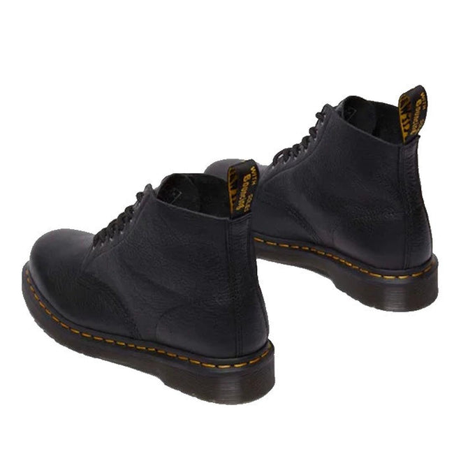 The Dr Martens 101 UB Black Ambassador 6 Eye Leather Boot features black leather, yellow stitching around the soles, and black pull tabs, shown from the back on a white background., 190665693683, 190665693690, 190665693706, 190665693720, 190665693737, 190665693744, 190665693768, 190665693775