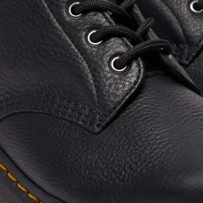 Close-up of the Dr Martens 101 UB Black Ambassador 6 Eye Leather Boot, showing its textured leather, black laces, metal eyelets, visible stitching, and the signature sole edge with yellow stitching., 190665693683, 190665693690, 190665693706, 190665693720, 190665693737, 190665693744, 190665693768, 190665693775