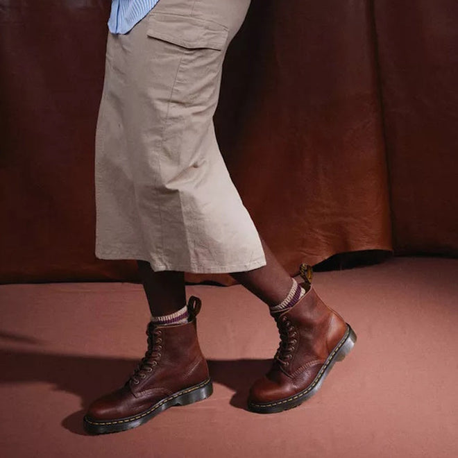 A model wearing a skirt, striped crew socks in beige and brown and Dr Martens Amabssador leather boots in cashew tan. In a walking stance showing the outer foot of the right foot & the inner of the left foot.,
190665662757,
190665662764,
190665662788,
190665662795,