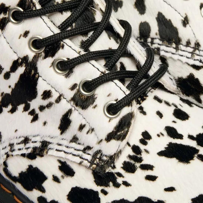 Close-up of the Dr Martens 1460 Bex Dalmatian Hair On Leather Lace Up Boot, featuring black laces, a white upper with black and brown cow-print spots, detailed stitching, eyelets, and a durable Goodyear welted sole., 190665780307, 190665780314, 190665780321, 190665780345, 190665780352, 51690