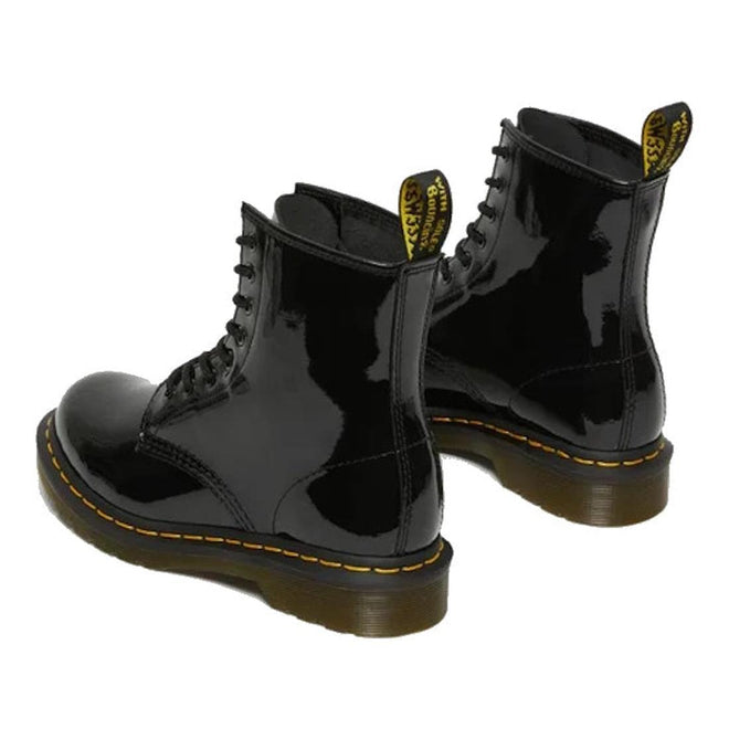 Black patent Dr Martens  leather boots with yellow stitching view from heel looking forward on a white background.,
883985035249,
883985035256,
883985035270,