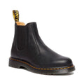 The Dr Martens 2976 Ambassador Black Leather Chelsea Boot features elastic side panels, a rear AirWair pull tab, yellow stitching, and a durable Goodyear-welted sole crafted from Ambassador leather.
