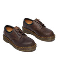 The Dr Martens 8053 Crazy Horse Dark Brown Leather 5 Eye shoe is a unisex lace-up with black trim, visible stitching, and thick air-cushioned rubber soles featuring yellow stitching around the edges., 52072, 52073, 800090801651, 800090801675, 800090801682, 800090801699, 800090801712