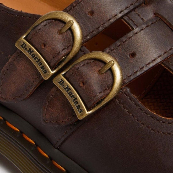 Close-up of the Dr Martens 8065 2 Strap Mary Jane Shoe in Crazy Horse Brown, featuring dual brass buckles with “Dr. Martens,” double stitching, and signature yellow welt stitching near the sole., 190665588941, 190665588958, 190665588965, 190665588972, 13164654654, 190665588996, 190665589009, 190665589016