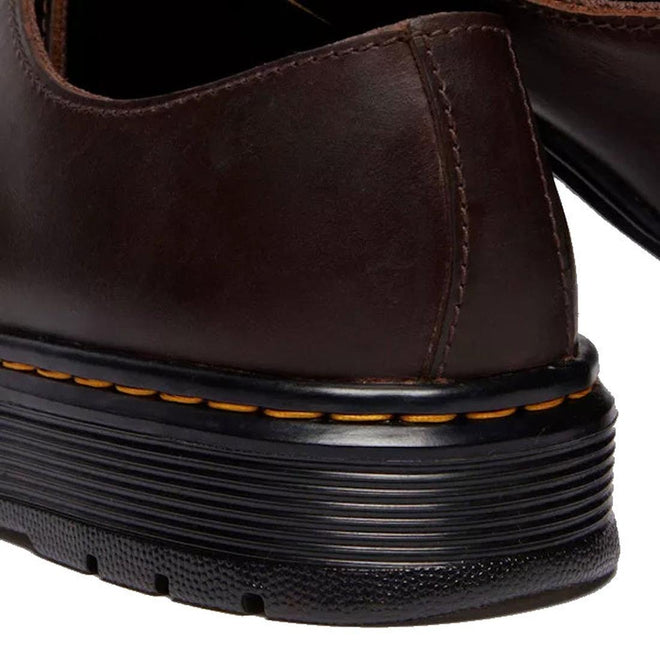 Close-up of the heel of a Dr Martens Brookline Lo Dark Brown Crazy Horse Leather Shoe, highlighting visible stitching and a black rubber sole with yellow stitching detail., 52062, 52063, 52064, 190665753912, 190665753936, 190665753943, 190665753950, 52069, 52070, 52071