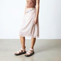 Person wearing a pink skirt with lace details showing the Dr Martens Grphon Quad sandals in pink on a plain background.,
190665714630,
190665714647,
190665714661,