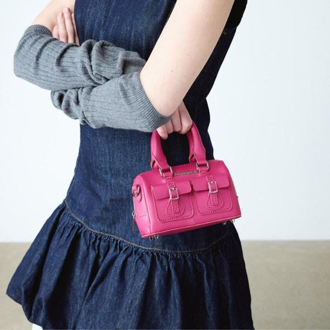 Person holding a pink handbag with a plain background,
190665739527,