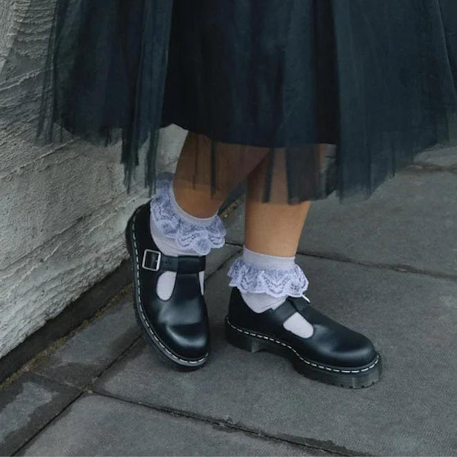 Black Polley Dr Martens T Bar Shoes shoes with white  socks and lace ruffles against a stone wall.,
190665696905,
190665696912,
190665696936,