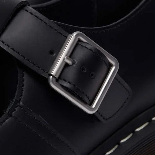 Close-up of a black leather DR Martens Polley T Bar with a silver buckle on a dark background.,
190665696905,
190665696912,
190665696936,