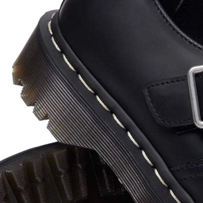 Close-up of a black leather Polley T Bar Dr Martens  shoe heel with a buckle and white stitching on a white background.,
190665696905,
190665696912,
190665696936,