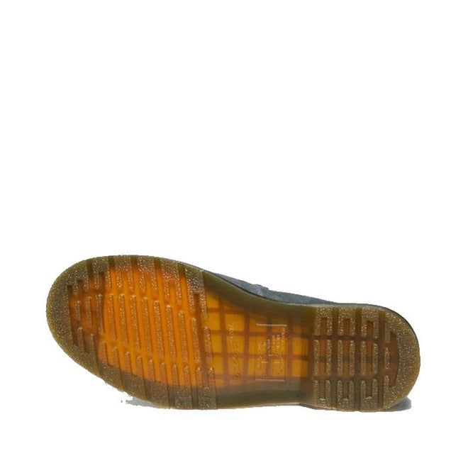The image shows the bottom view of a Dr Martens Adrian Snaffle Loafer Washed Denim Tumbled Nubuck with a translucent rubber sole featuring grid and groove patterns, displayed on a white background.