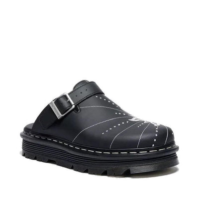 The Dr Martens Zebzag Mule Solar Flare Genix Nappa Black is a black slip-on clog with a thick ergonomic sole, decorative white stitching, and an adjustable buckle strap across the top.