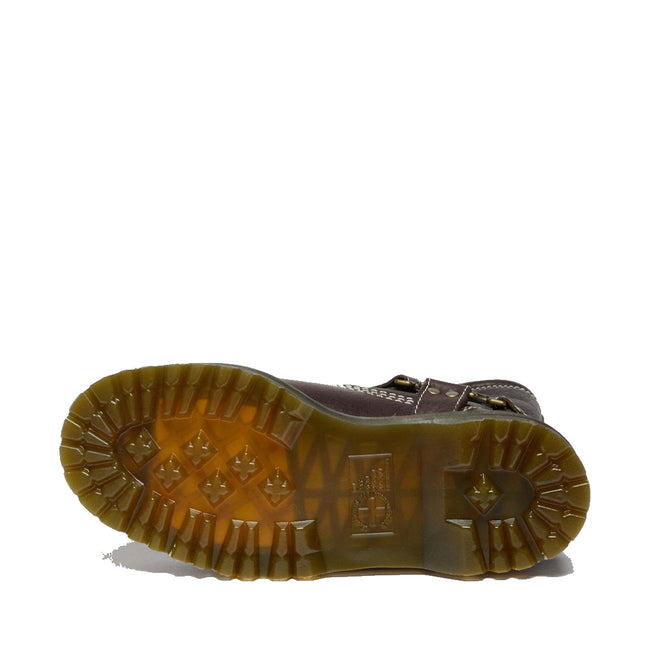 The Dr Martens Anistone Hi Flower Bex Grizzly Dark Brown boot is shown from below, showcasing its thick, translucent rubber sole with deep treads, geometric shapes, and textured details for enhanced grip and traction.