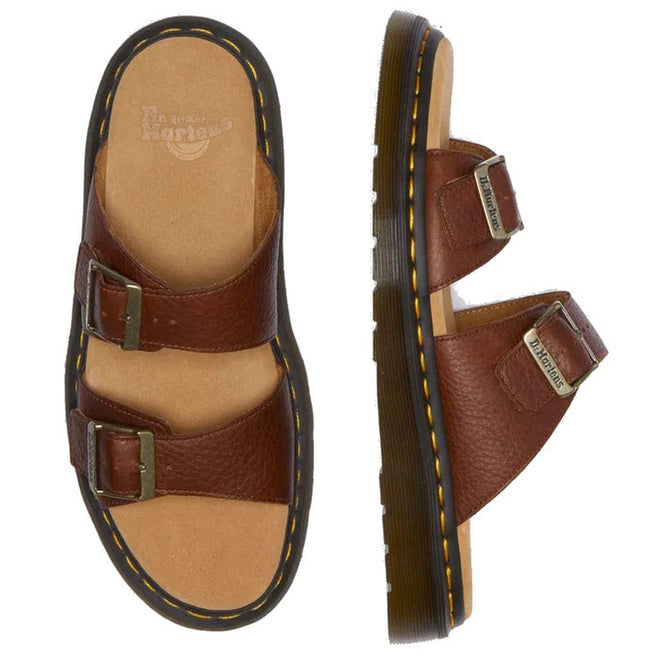 A pair of Dr Martens Josef Slide Sandal Cashew Ambassador Leather with two adjustable buckle straps, a thick sole, yellow stitching, and Goodyear welted construction, shown from the top and side views.