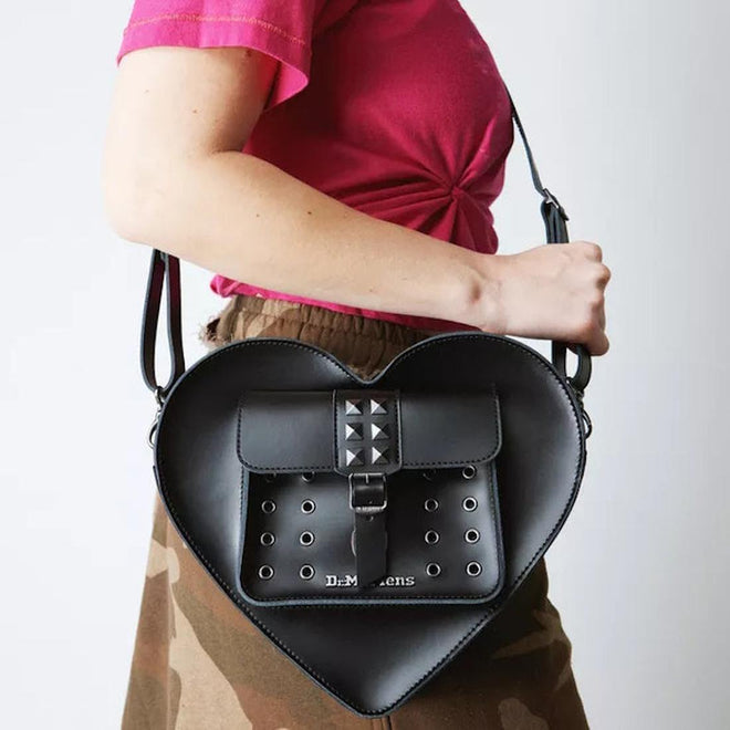 A side view of a women carrying the dr martens heart bag over her shoulder, showing the size
190665728408